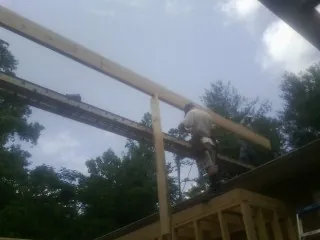 Carpenter setting a ridge beam over a new addition frame — Ice Dam Removal by Roofing Brothers in Cardington