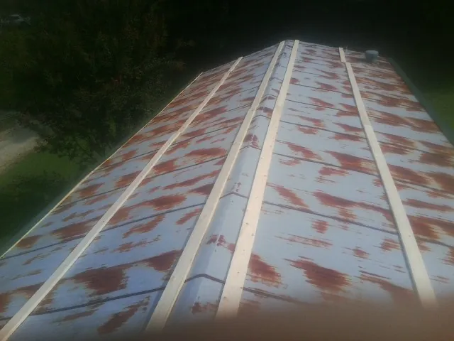 Rusted metal roof panels with new wood purlins before replacement — Storm Damage Roof Repair in Cardington by Roofing Brothers