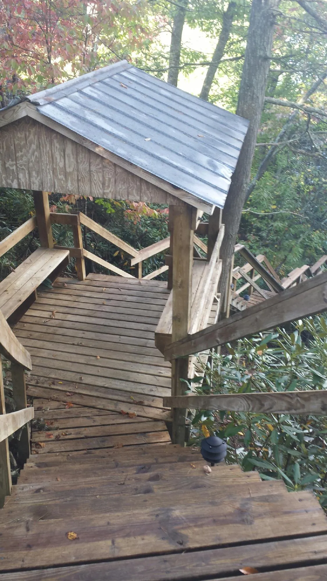 Metal roofed shelter over wooden steps on a wooded walkway — Skylight Repair & Installation work by our crew in Cardington