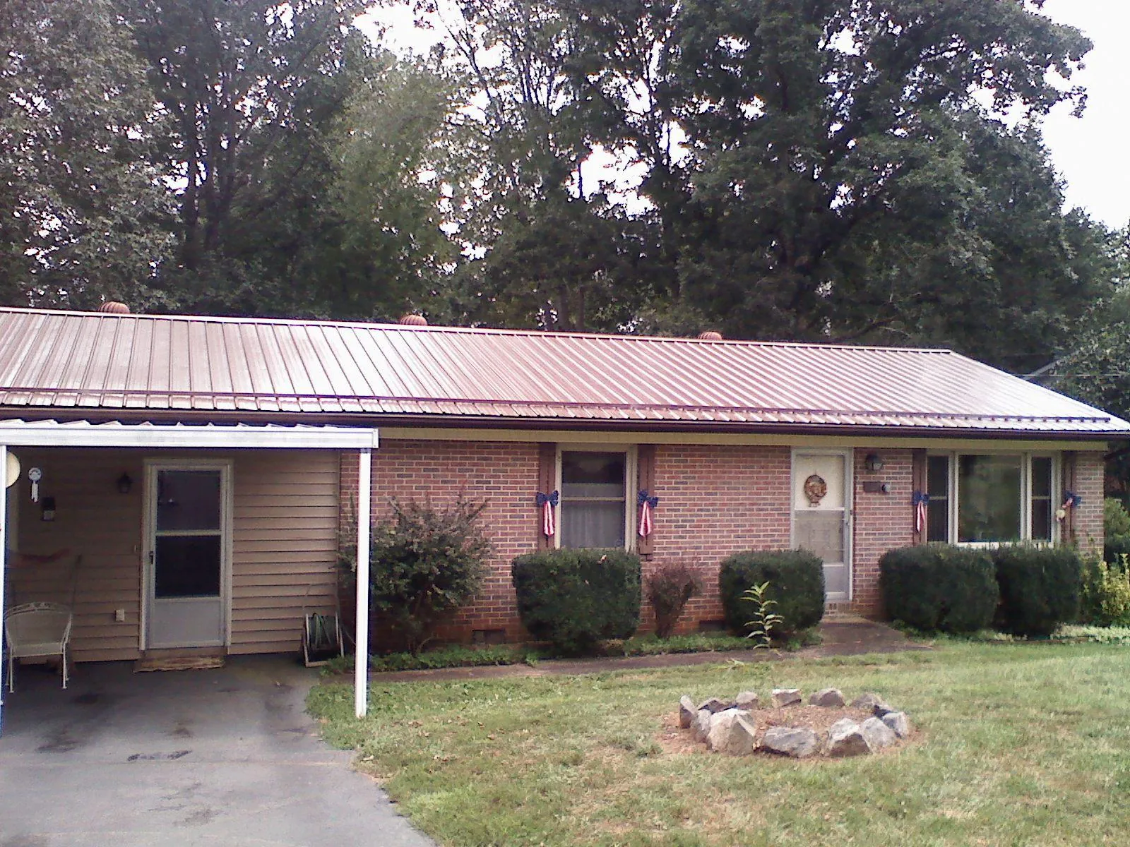 Bronze metal roof and carport on a brick ranch home — Roof Repair work by our crew in Cardington